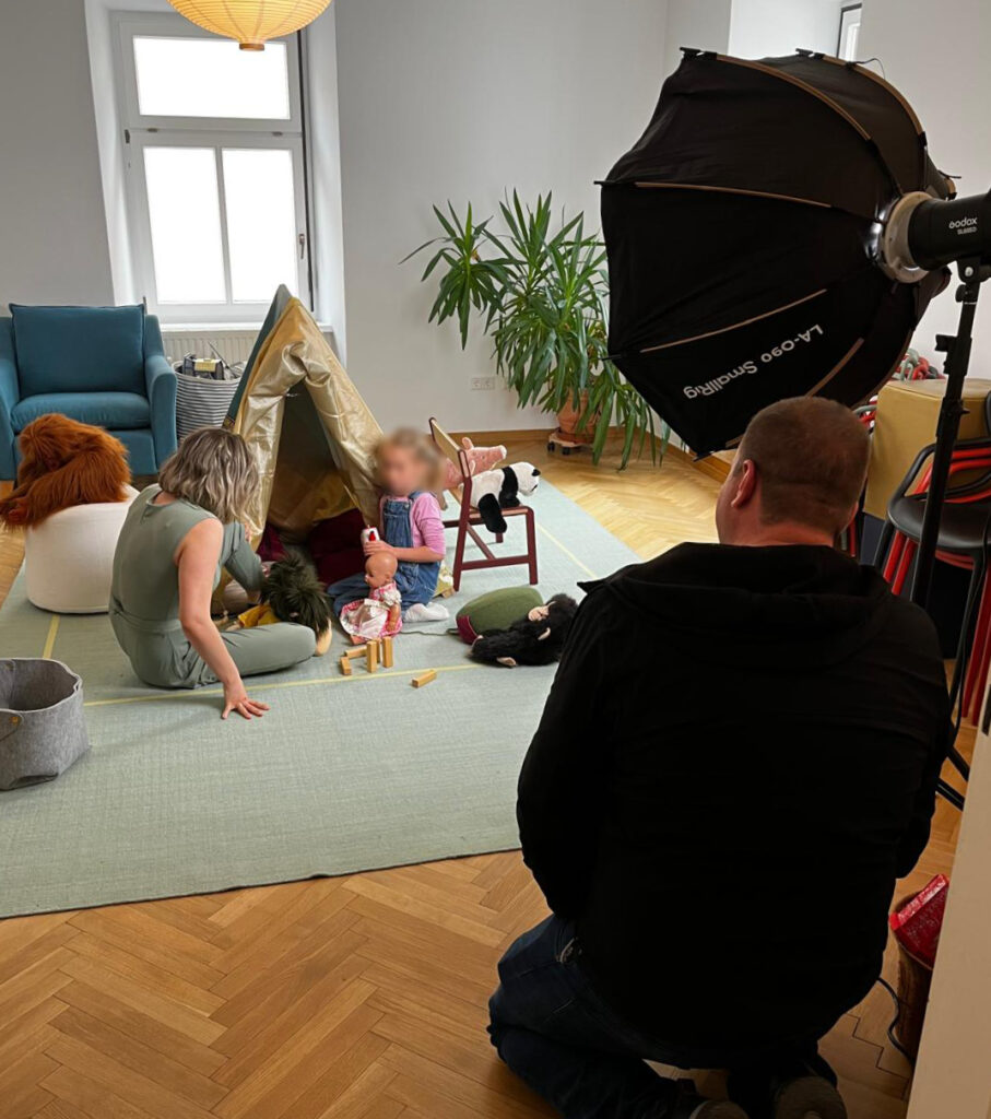 Bild mit Fotografen und Model. Weiters befindet sich auf dem Bild ein Kind vor einem Zelt